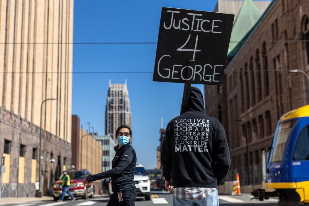 A demonstrator hold a sign "Justice for George" outside the Hennepin County Government Center during the opening statement of former Minneapolis Police officer Derek Chauvin on March 29, 2021 in Minneapolis, Minnesota. (Kerem Yucel/AFP via Getty Images)