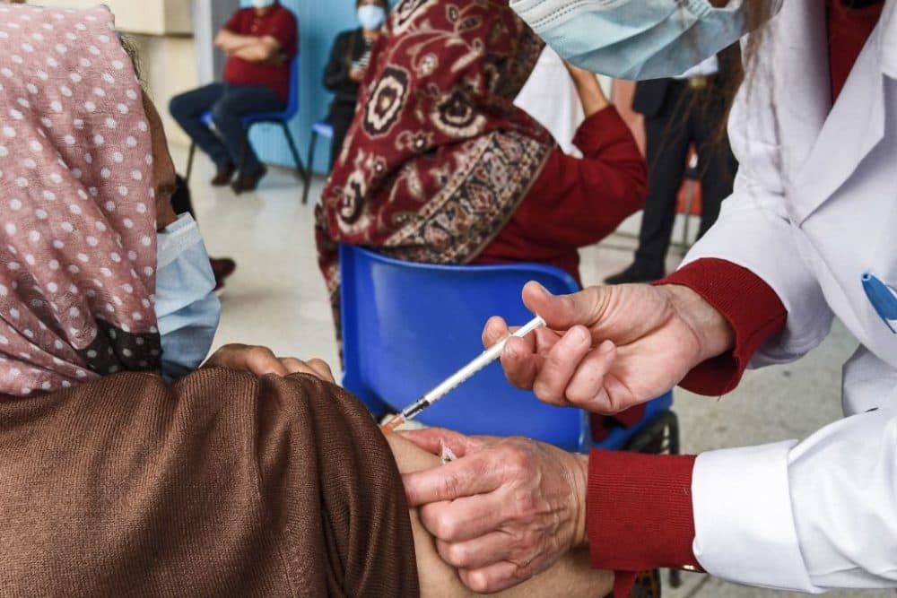 A woman receives a dose of the Pfizer-BioNTech COVID-19 vaccine ahead of the Muslim holy fasting month of Ramadan. (Fethi Belaid/AFP/Getty Images)