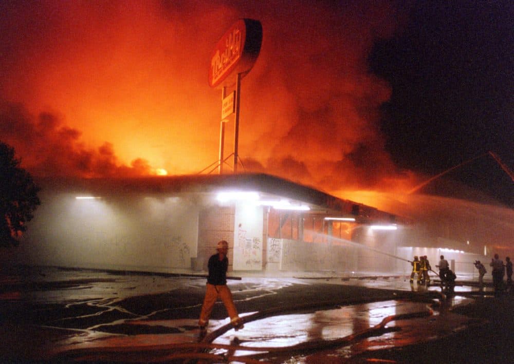 Flames roar from a Thrifty Drug store in the Crenshaw area of Los Angeles, 29 April 1992. Riots broke out in Los Angeles, 29 April 1992, after a jury acquitted four police officers accused of beating a black youth, Rodney King, in 1991, hours after the verdict was announced. (Mike Nelson/AFP via Getty Images)