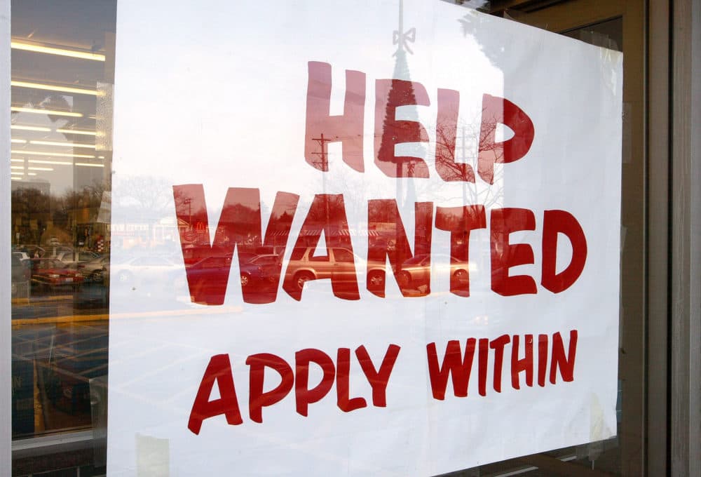 A sign that reads "Help Wanted Apply Within" is seen hanging in a window of a beverage store. (Tim Boyle/Getty Images)