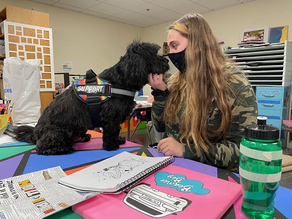 Senior Carly Baker with North Shore Recovery High's service dog, Franklin. (Courtesy Mary Devin/North Shore Recovery High School)