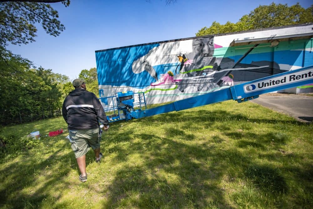 Artist Cedric Douglas approaches the mural he is installing at the Medfield State Hospital. (Jesse Costa/WBUR)