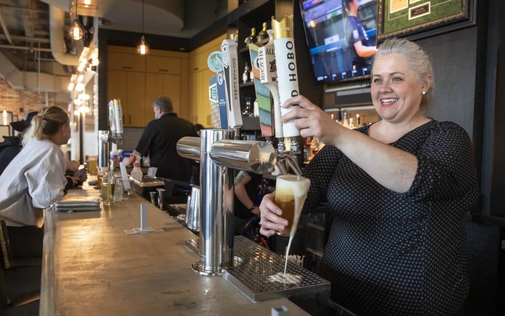 Kimberly Sapp, general manager of the A&B Kitchen • Bar, draws a beer from the tap on Saturday. (Robin Lubbock/WBUR)