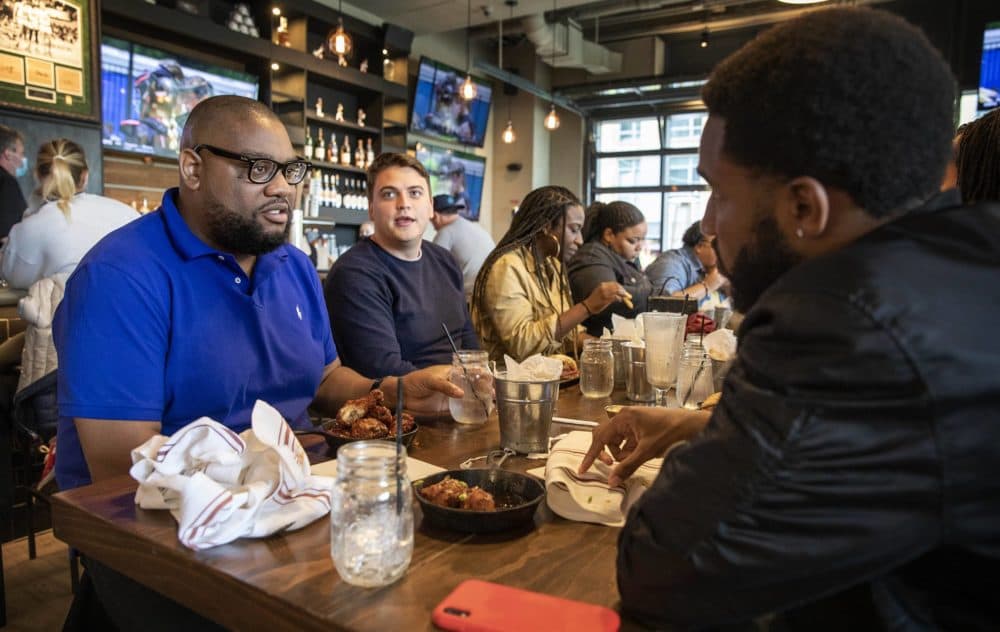 Leonard Rowan has lunch with friends at the A&B Kitchen • Bar, on Saturday, the first day all restrictions on indoor gatherings are lifted in Boston. (Robin Lubbock/WBUR)