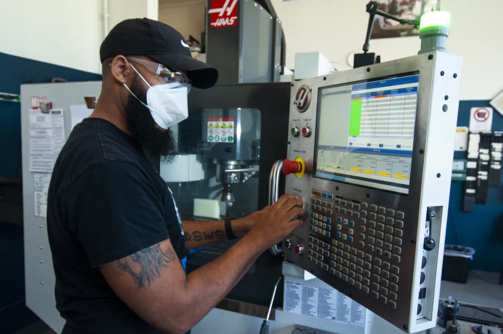 Adonis Summerville punching in instructions to a computer numerical control (CNC) machine at the Jane Addams Resource Corporation (JARC). (Chris Bentley/Here & Now)