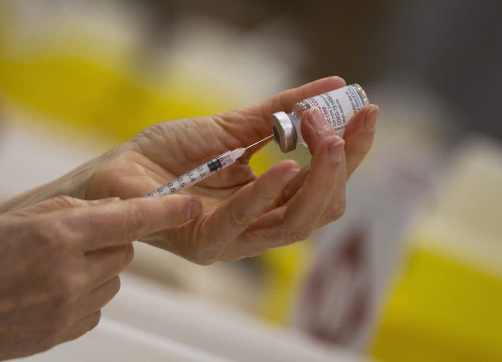 In this file photo dated April 14, 2021, a pharmacist fills a syringe from a vial of the Moderna COVID-19 vaccine in Antwerp, Belgium. (Virginia Mayo/AP FILE)
