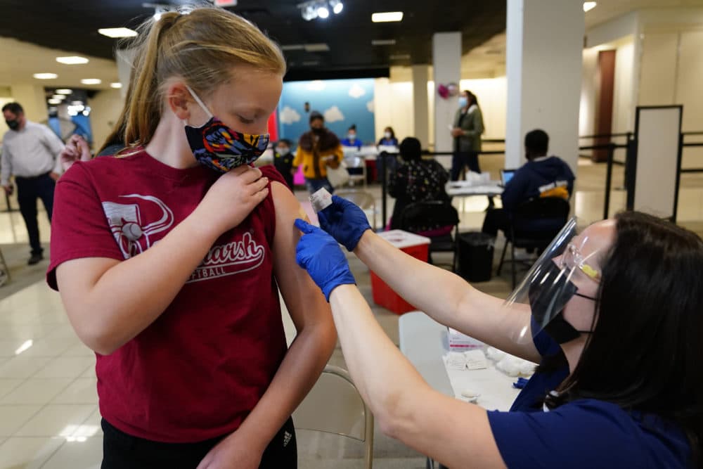 Olivia Edwards, left, 13, of Flourtown, Pa., gets a bandage from registered nurse Philene Moore after getting a Pfizer COVID-19 vaccination at a Montgomery County, Pa. Office of Public Health vaccination clinic at the King of Prussia Mall, Tuesday, May 11, 2021, in King of Prussia. (AP Photo/Matt Slocum)