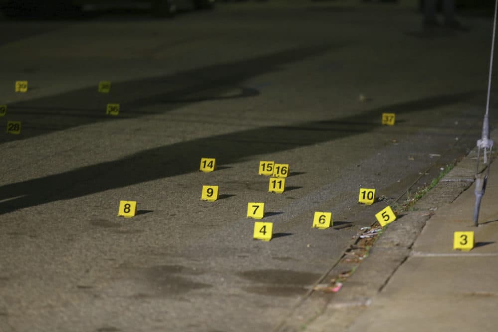 Evidence markers line the street outside a house on Carolina Avenue after the shooting, May 13, 2021, in Providence. (Stew Milne/AP)