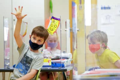 Kindergarten students wear their masks and are separated by plexiglass during a math lesson at the Milton Elementary School, on May 18, 2021, in Rye, N.Y. (Mary Altaffer/AP)