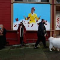 People pass by a mural of poet Amanda Gorman, painted by San Francisco muralist Nicole Hayden, center, on Page Street on Thursday, Jan. 28, 2021 in San Francisco, California. (Gabrielle Lurie/The San Francisco Chronicle via Getty Images)