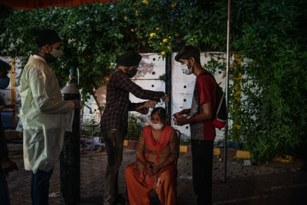 Volunteers treat patients suffering from Covid-19 with free oxygen at a makeshift clinic in a parking lot outside the Gurdwara Damdama Sahib on May 03, 2021 in New Delhi, India. (Rebecca Conway/Getty Images)