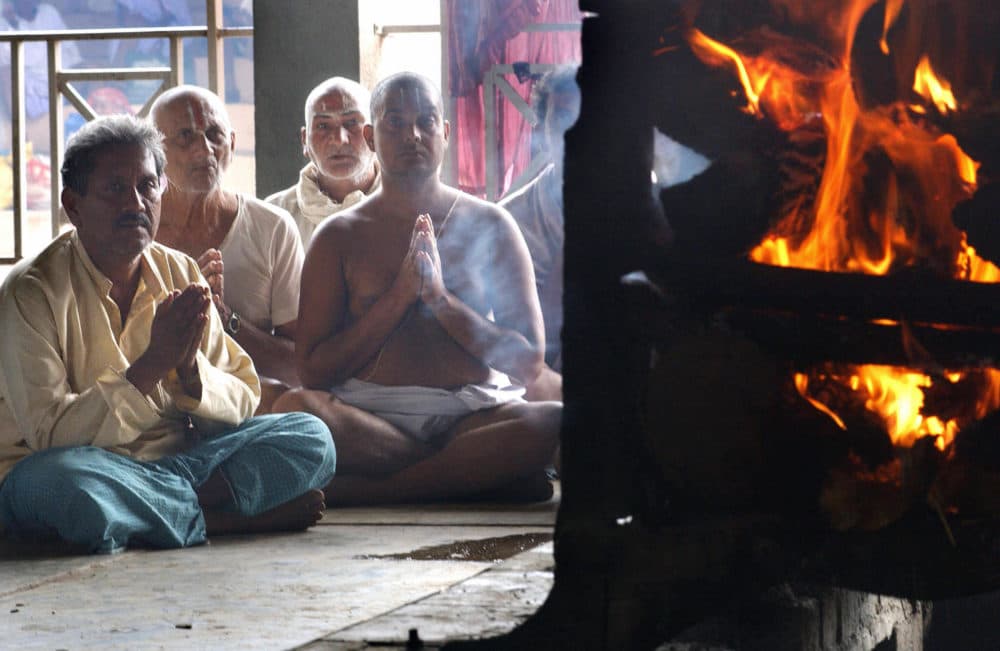 Indian Hindu man Jeet Bahadur Singh (L) prays along with priests as he watches his wife's cremation at the Panchavati Amar Dham crematorium in Nashik, 28 August 2003 some 187 kms (116 miles) north of Bombay. At least 45 people were killed and more than 70 injured in a 27 August stampede by Hindu worshippers rushing to bathe in one of western India's holiest rivers at the Kumbh festival held every three years. AFP PHOTO/INDRANIL MUKHERJEE (Photo credit should read INDRANIL MUKHERJEE/AFP via Getty Images)