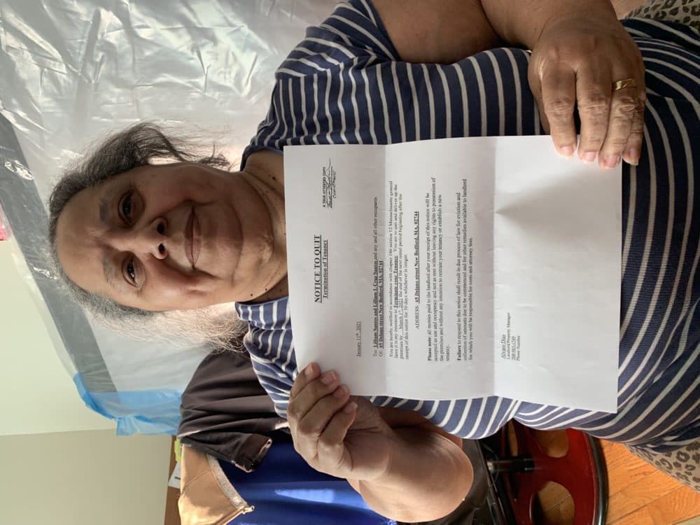 New Bedford resident Liliana Cruz holds up a copy of the eviction letter she received in January. The landlord wants her out by the end of May. (Simón Rios/WBUR)