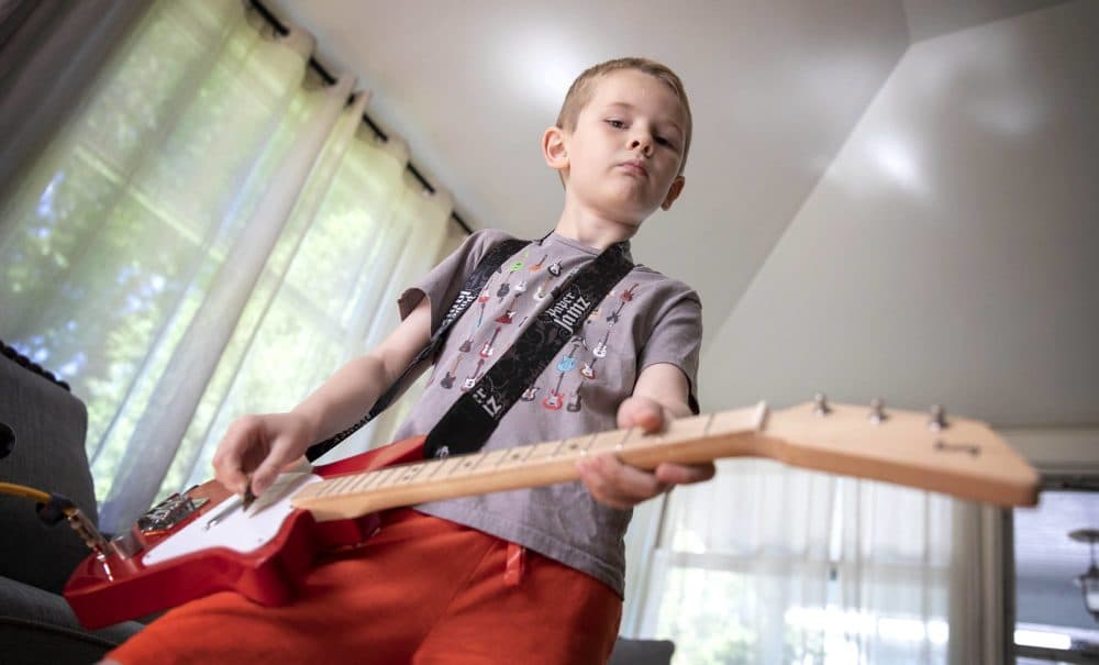 Arlen gets in some practice on his electric guitar. The young musician is the inspiration for "The Boy Who Wanted to Rock," written by his father Dave Weiser. (Robin Lubbock/WBUR)