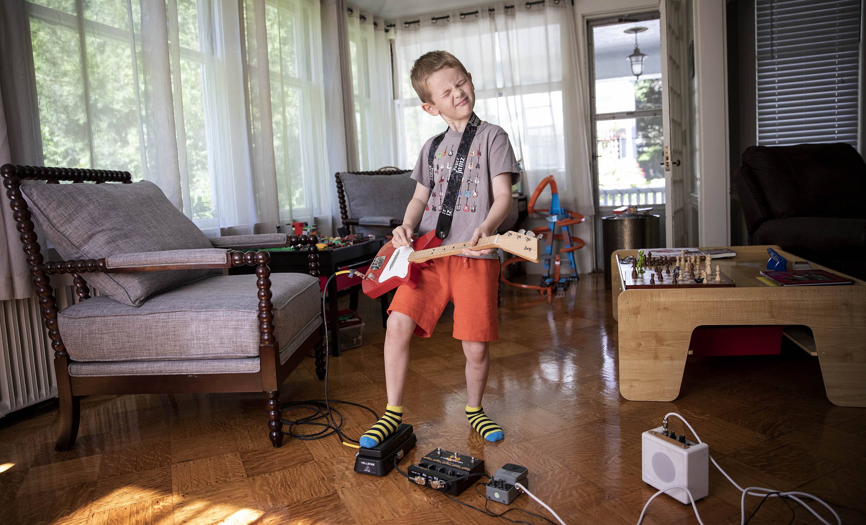 Arlen gets in some practice on his electric guitar. The young musician is the inspiration for "The Boy Who Wanted to Rock," written by his father Dave Weiser. (Robin Lubbock/WBUR)
