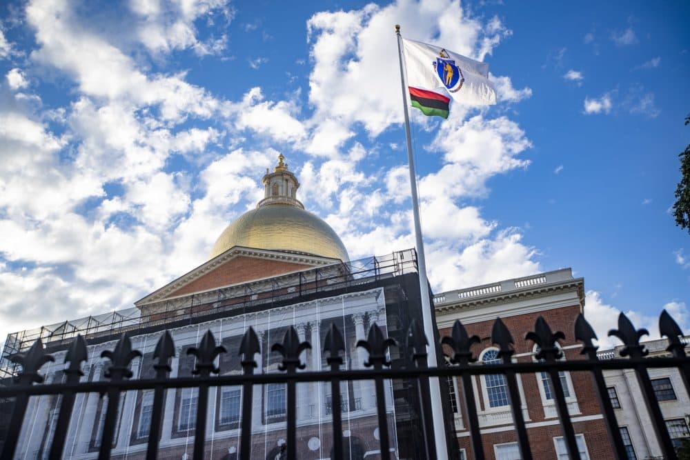 A red, black and green Pan-African flag flies beneath the Massachusetts state flag in front of the State House to commemorate the first Juneteenth holiday recognized by the state. (Jesse Costa/WBUR)