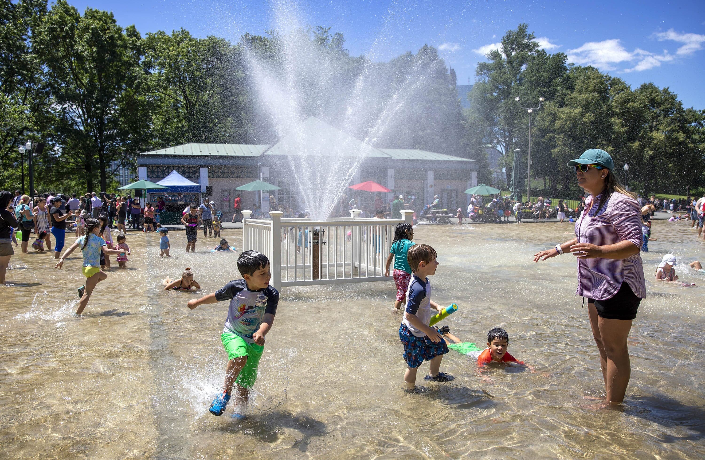 Children splash through the water by the fountain at the summer opening of Boston's Frog Pond. (Robin Lubbock/WBUR)