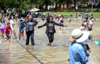 Boston Mayor Kim Janey joins visitors wading through the Frog Pond at the pond's summer opening event on Thursday. (Robin Lubbock/WBUR)