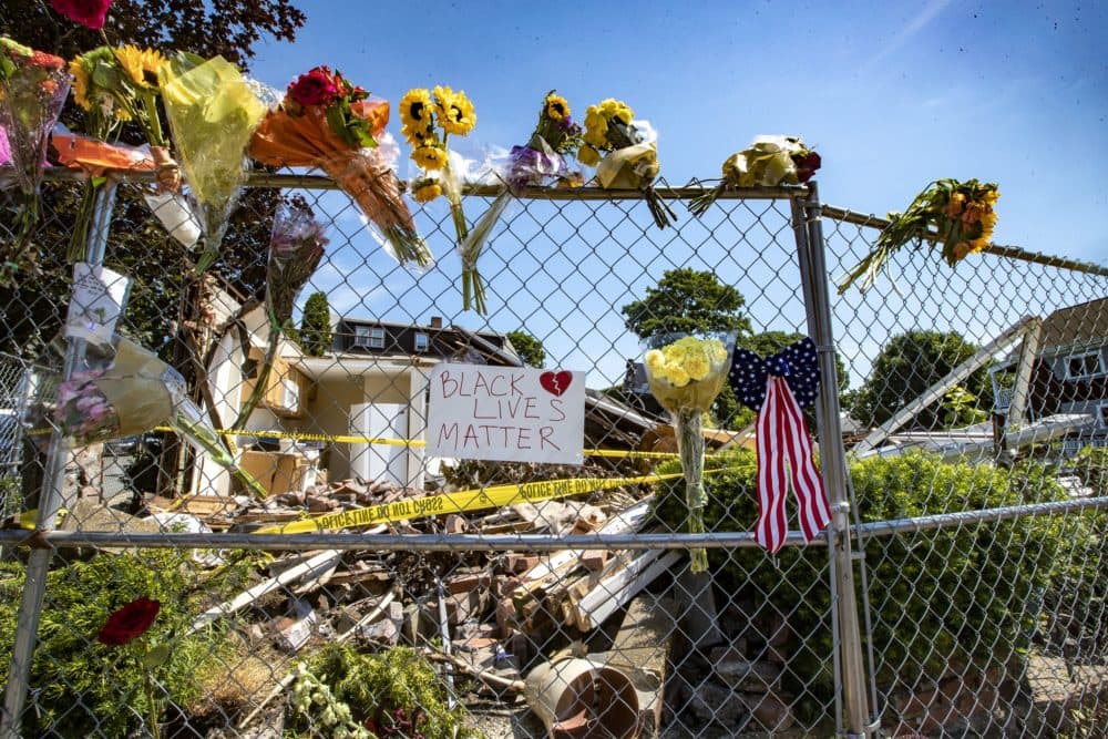Flowers are seen near where a gunman killed two people after crashing a stolen truck on Saturday in Winthrop. (Jesse Costa/WBUR)