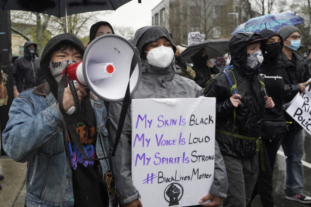Demonstrators display placards while marching during a protest, Wednesday, April 21, 2021, in the Nubian Square neighborhood of Boston, a day after a guilty verdict was announced at the trial of former Minneapolis police officer Derek Chauvin for the 2020 death of George Floyd. (Steven Senne/AP)
