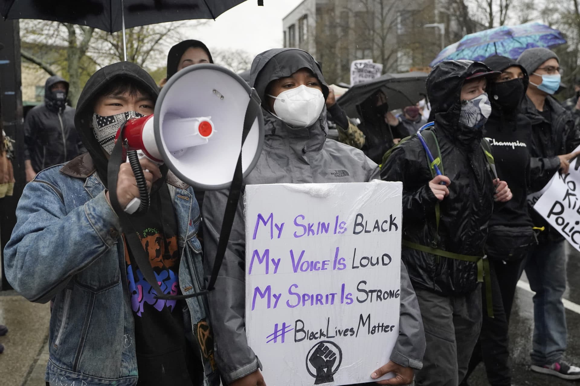 Demonstrators display placards while marching during a protest, April 21, 2021, in the Nubian Square neighborhood of Boston, a day after a guilty verdict was announced at the trial of former Minneapolis police officer Derek Chauvin for the 2020 death of George Floyd. (Steven Senne/AP)