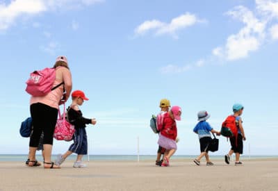 A summer camp monitor looks after children (Philippe Huguen/AFP via Getty Images)