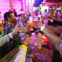 Emily Baumgartner, left, and Luke Finley, second from left, join friends in a birthday toast at the Tiki Bar on Manhattan's Upper West Side Monday, May 17, 2021, in New York. Restaurants, shops, gyms and many other businesses in New York can go back to full occupancy if all patrons are inoculated. (Kathy Willens/AP)