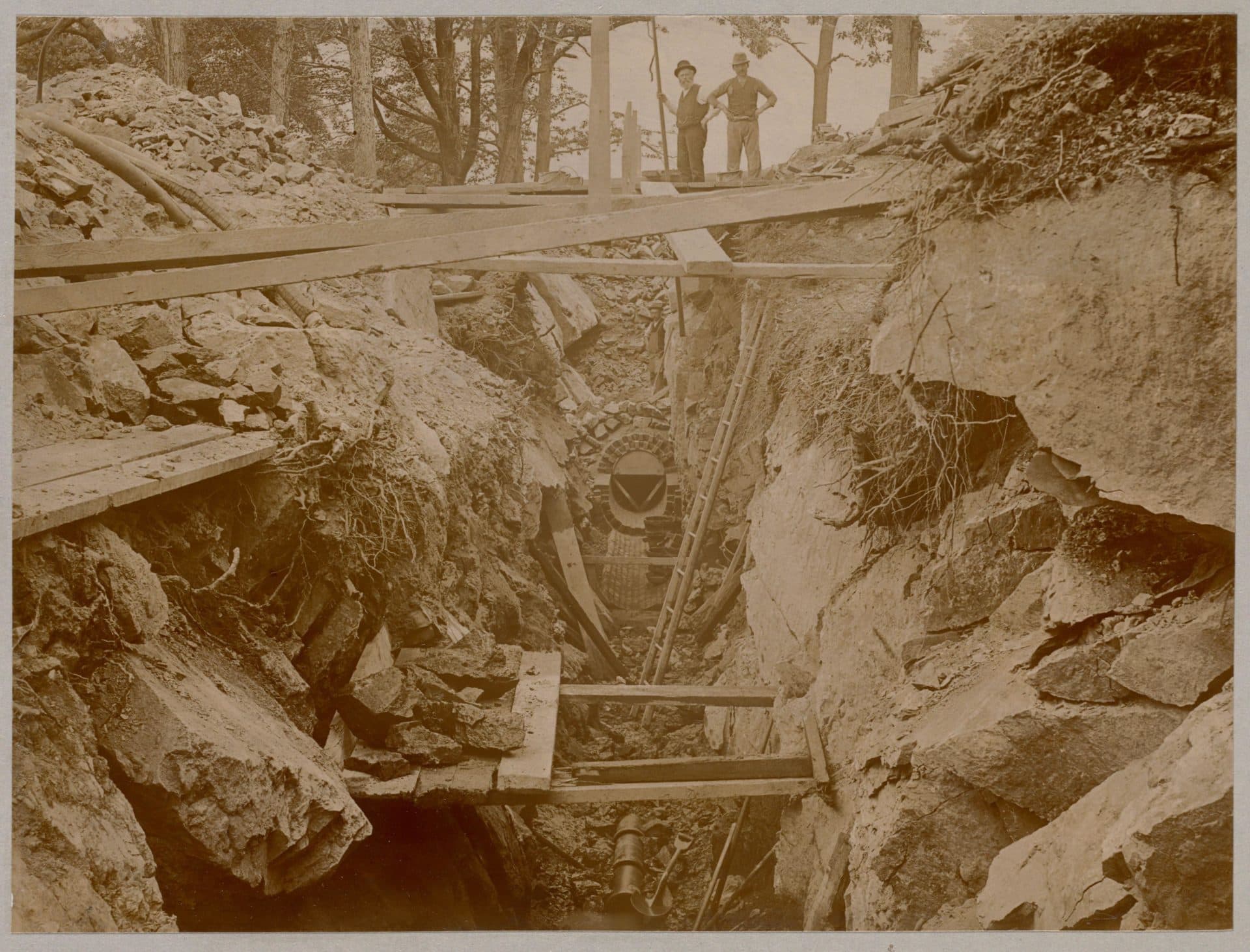 Men stand over an unfinished sewer being built in the 1880s (Courtesy Boston Public Library)