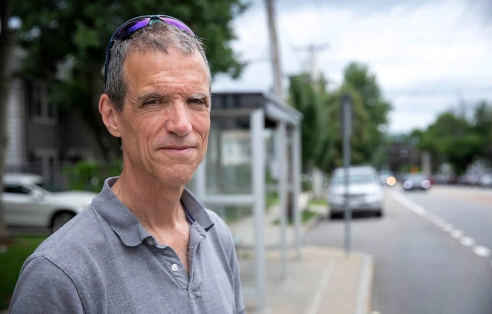 State Sen. Will Brownsberger standing at a bus stop in Belmont. (Robin Lubbock/WBUR)