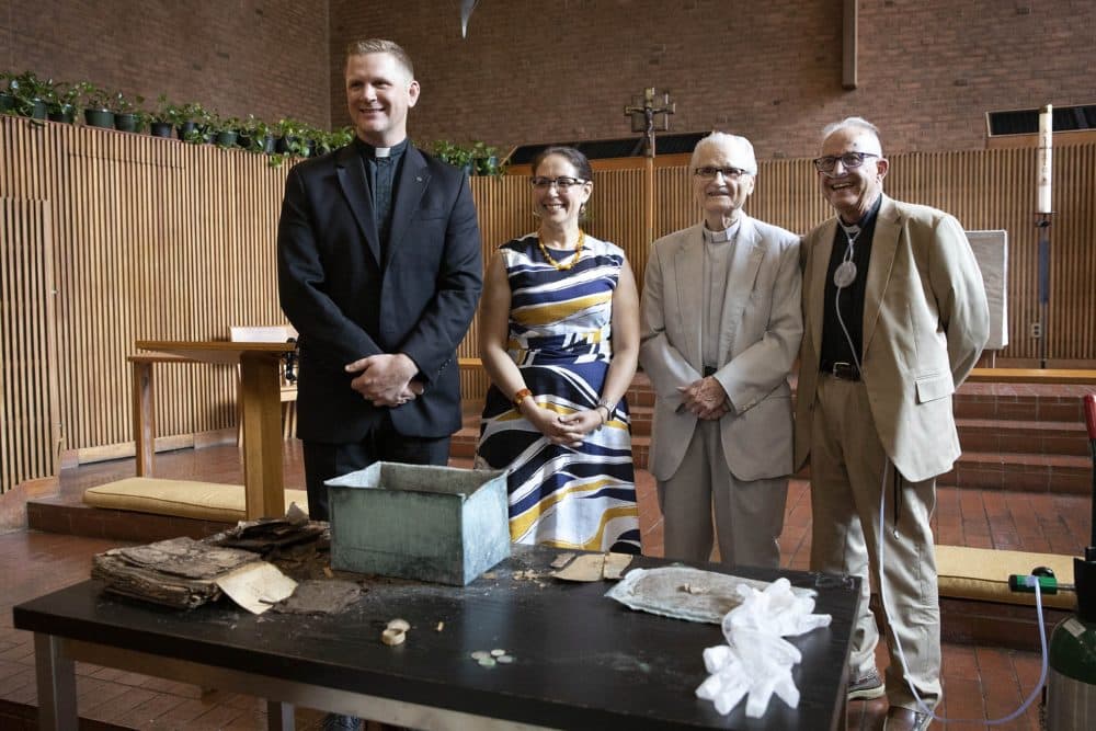 First Lutheran Church of Boston pastors Rev. James Hopkins, Rev. Walter Reuning and Rev. Ingo Dutzmann, stand for a photo with Dr. Vanessa Calderón-Rosado, after the opening of the 1898 copper box. (Robin Lubbock/WBUR)