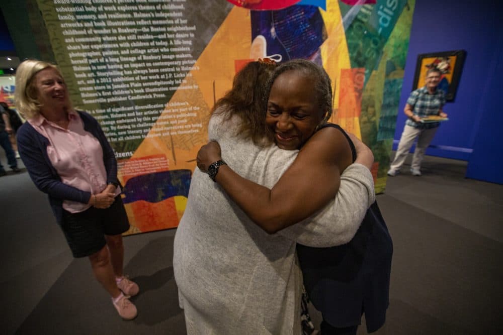 Ekua Holmes is embraced by Quincy Catholic Academy school teacher Carolyn Major, showing her appreciation for Holmes’ illustration work in children’s books. (Jesse Costa/WBUR)