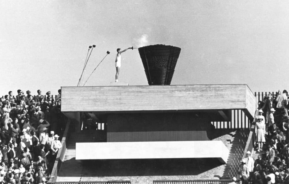 In this Oct. 10, 1964 file photo, Japanese runner Yoshinori Sakai lights the Olympic cauldron during the opening ceremony of the 1964 Summer Olympics in Tokyo. Sakai was born in Hiroshima on Aug. 6, 1945, the day the nuclear weapon destroyed the city. He symbolized the rebirth of Japan after World War II as he opened the 1964 Tokyo Games. (AP)