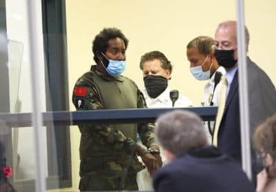 Quinn Cumberlander, left, one of 11 people charged in connection with an armed standoff on I-95 last weekend, appears during his arraignment at Malden District Court on Tuesday.  (Suzanne Kreiter/The Boston Globe via AP, Pool)