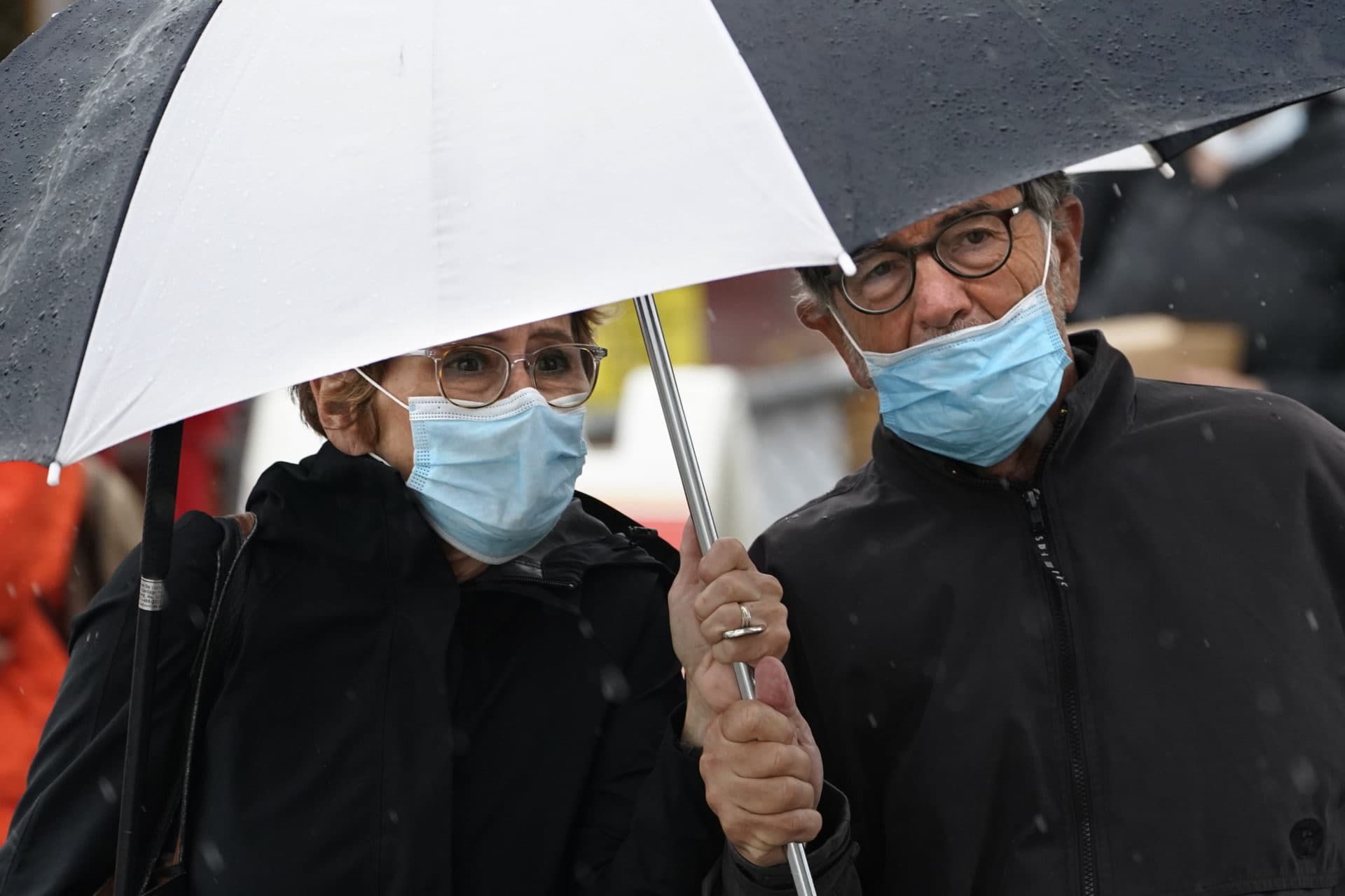Joanne MacIsaac and Ron Delucia, of Medford share an umbrella as the remnants of the storm arrive in Portland, Maine. Robert F. Bukaty/NPR)