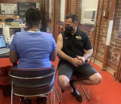 Alberto Nieves receives his COVID-19 vaccine at Springfield Technical Community College. (Paris Alston/WBUR)