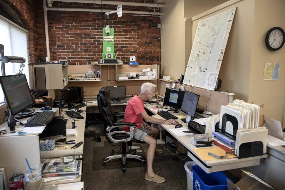 Netværksadministrator Mike Mansir omgivet af overvågningsudstyr på C-10-kontoret i Amesbury, Massachusetts.  (Robin Lubbock/WBUR)