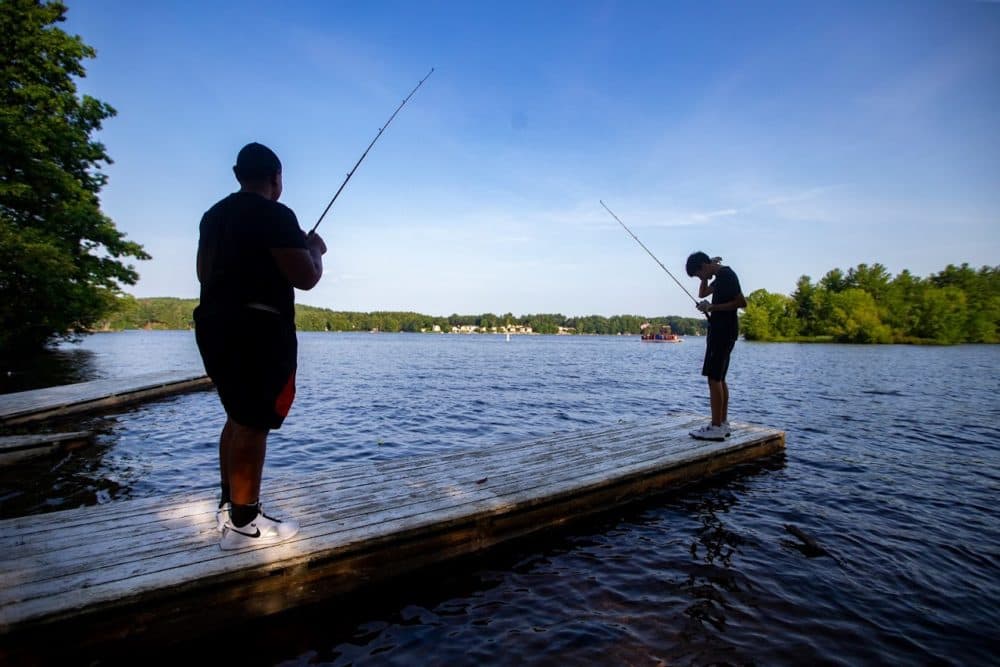 Chaun’cee Smith and Josiah Lopez fish off a dock in Lake Lashaway at Camp Atwater in North Brookville. (Jesse Costa/WBUR)