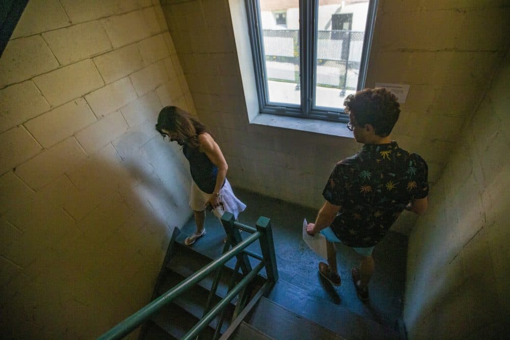 Real estate agent Lourdes Hernández and Leon Vasershteyn walk down to the basement to check out the pool, laundry facilities and parking garage of a condominium for sale in Brookline. (Jesse Costa/WBUR)