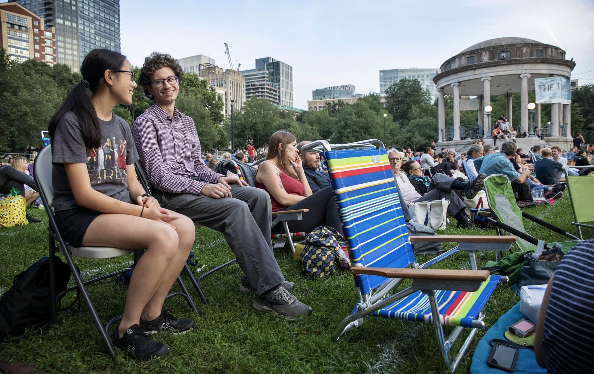As evening falls, Northeastern students Sam Wohlever and Amanda Dee wait for the start of the "The Tempest" on Boston Common. (Robin Lubbock/WBUR)