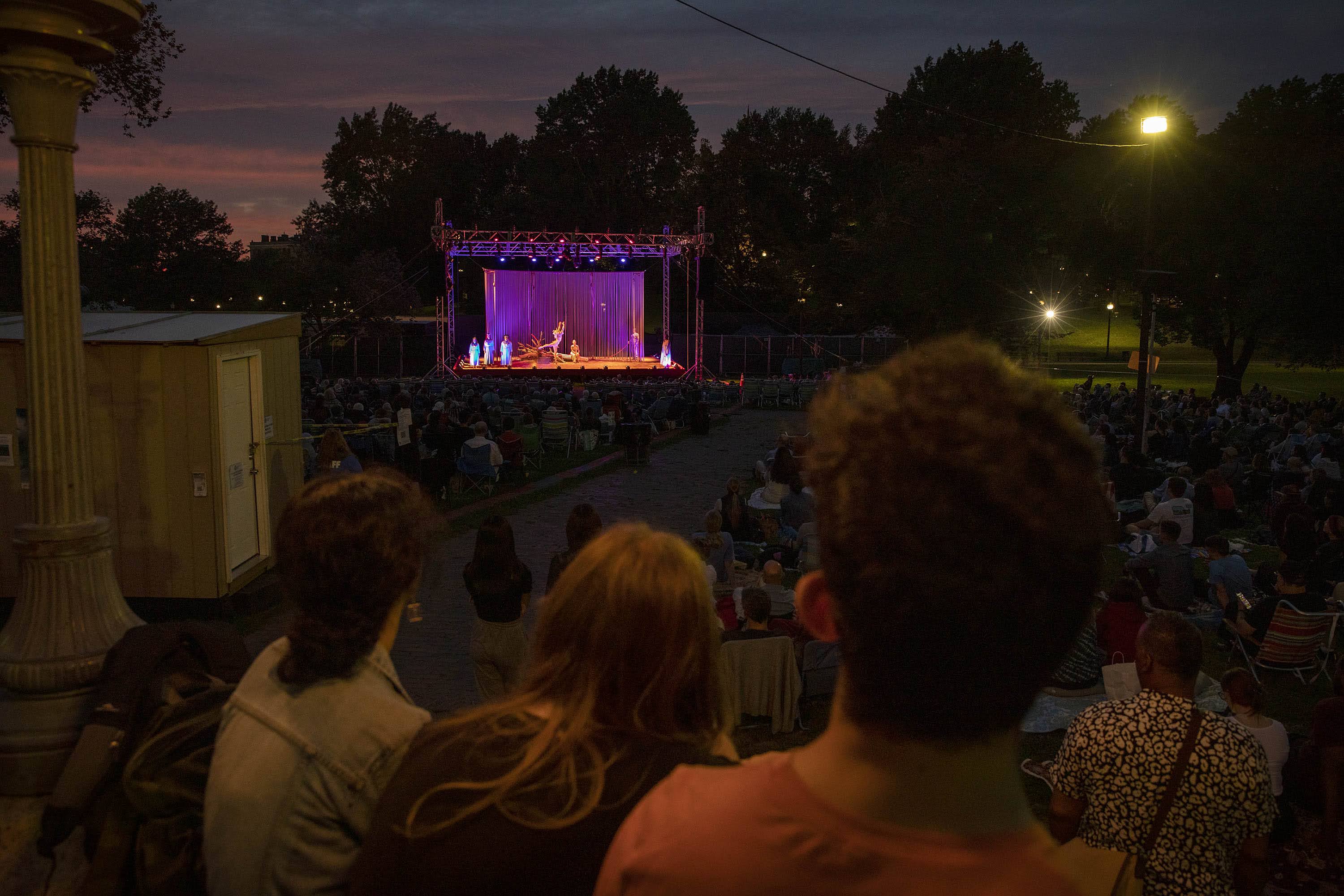 Some audience members sit on the steps on the bandstand to watch the performance of Commonwealth Shakespeare Company's production of "The Tempest." (Robin Lubbock/WBUR)