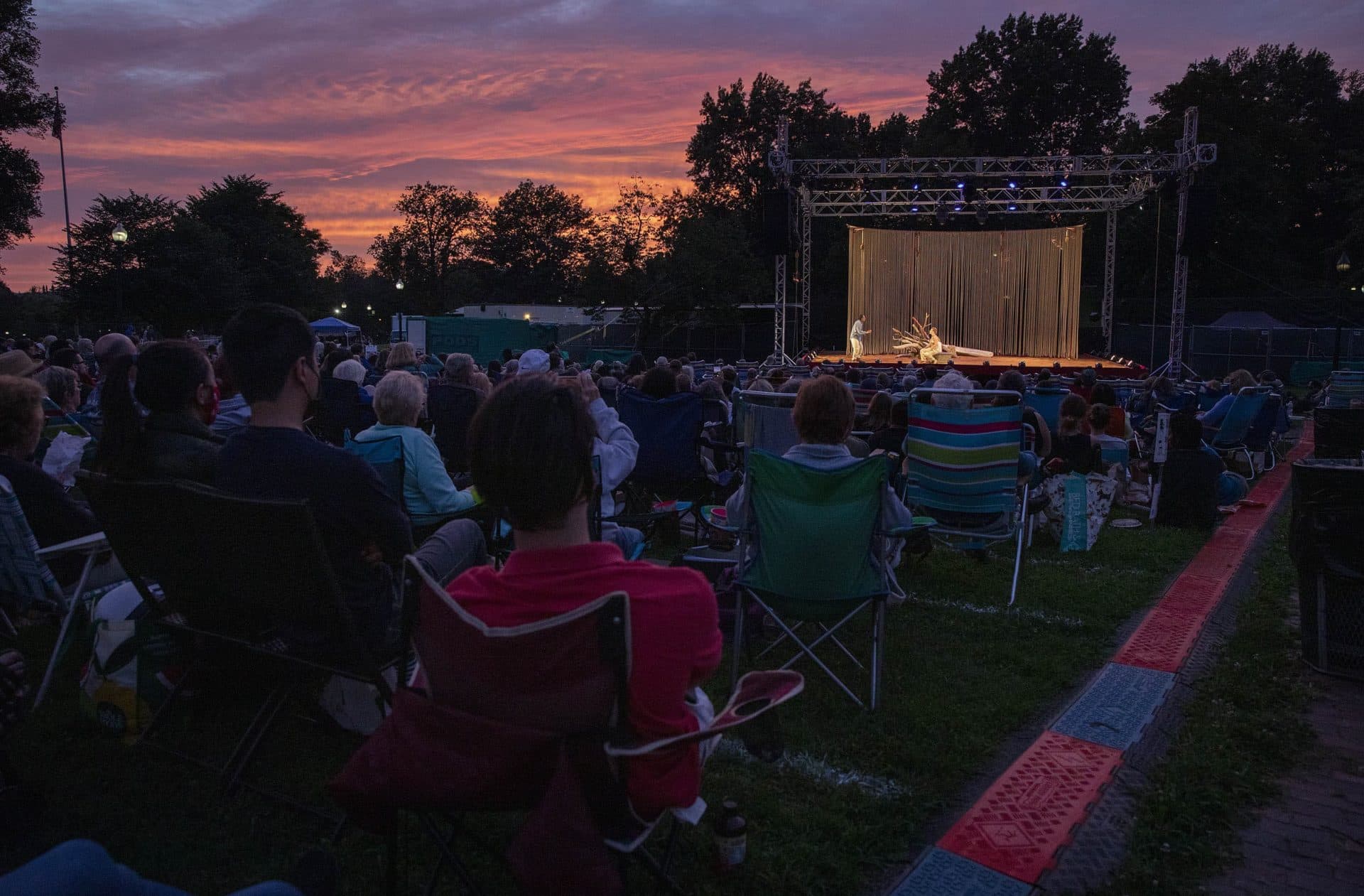 Sitting on deck chairs and blankets, the audience watches the Commonwealth Shakespeare Company's performance of "The Tempest." (Robin Lubbock/WBUR)