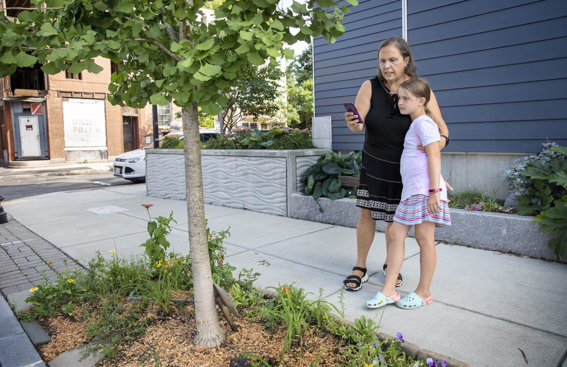 Eugenia Corbo and her daughter, Maite, enter data about their chosen ginkgo tree in East Boston into the MyTree app. (Robin Lubbock/WBUR)