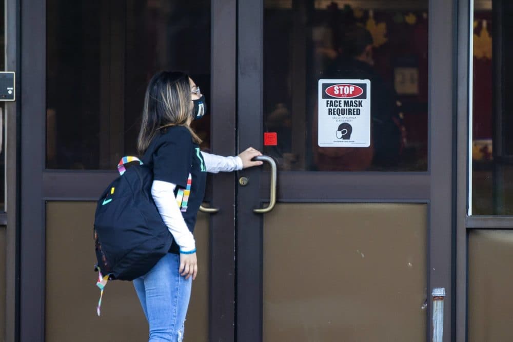 A student walks into New Bedford High School in the early morning, Nov, 2020. (Jesse Costa/WBUR)