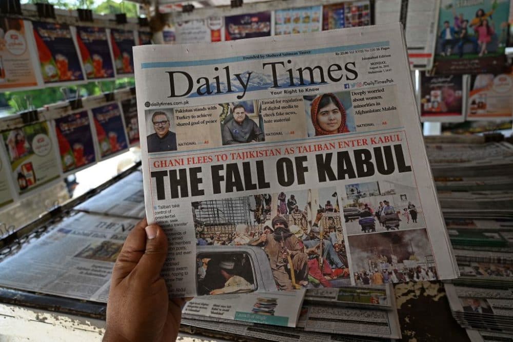 A man holds a newspaper displaying front page news about Afghanistan, at a stall in Islamabad on August 16. (Aamir Qureshi/AFP/Getty Images)