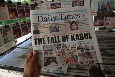 A man holds a newspaper displaying front page news about Afghanistan, at a stall in Islamabad on August 16. (Aamir Qureshi/AFP/Getty Images)