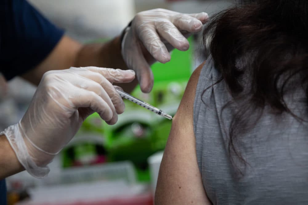 A pharmacist administers a third dose of the Moderna COVID-19 vaccine. (Emily Elconin/Getty Images)