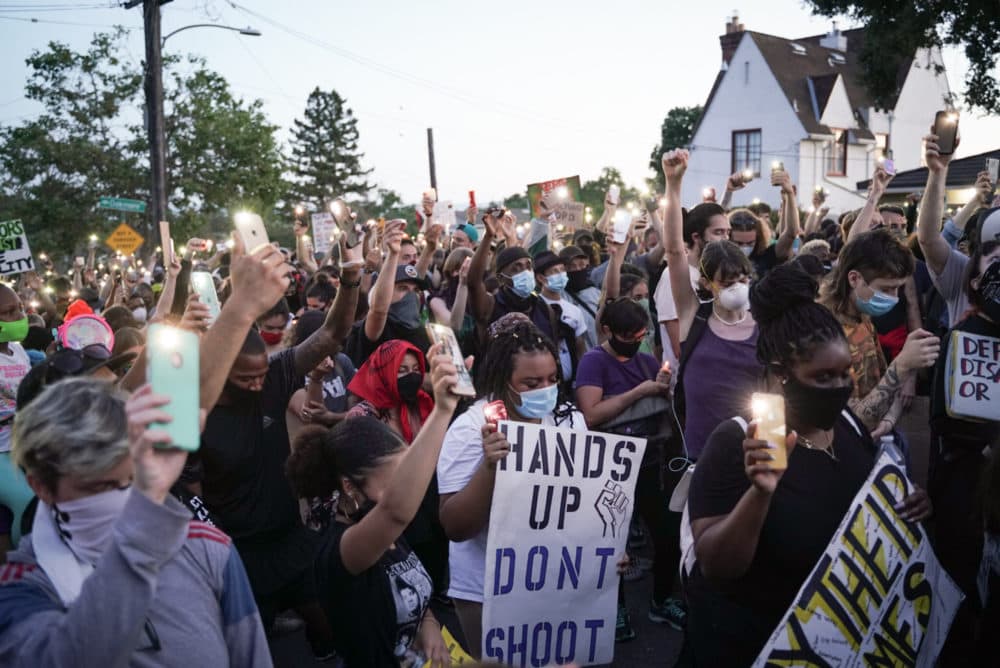 Demonstrators light candles during a 2020 protest to defund the Oakland Police Department. (Sarahbeth Maney/The San Francisco Chronicle via Getty Images)