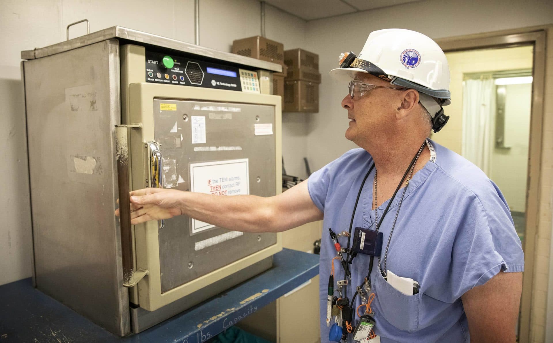 Radiation Protection Technologist Adrian Lombardo checks equipment for any radioactivity before allowing it into the work area. He'll check again when it comes out. (Robin Lubbock/WBUR)