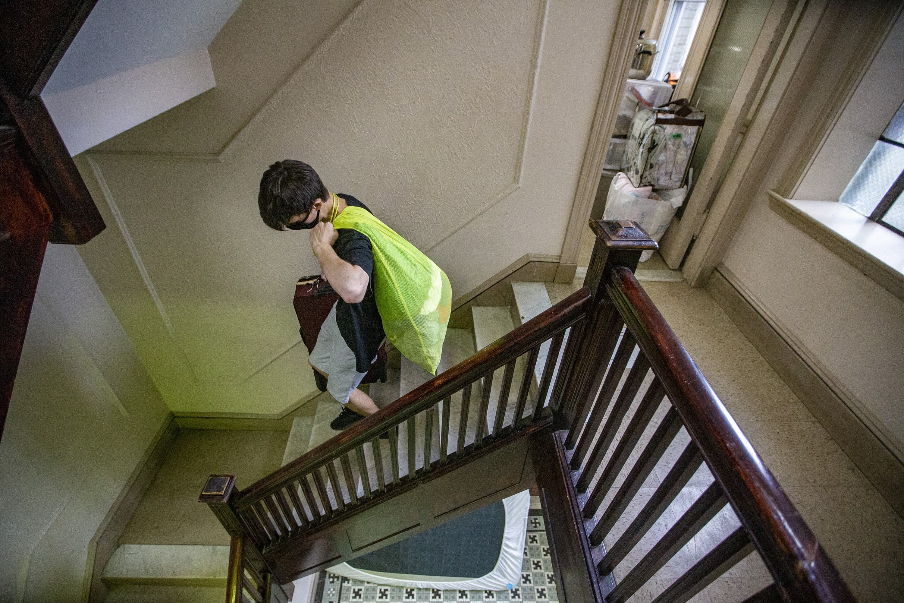 Mike Totten carries some of his belongings down the stairwell of his girlfriend’s apartment building while moving. (Jesse Costa/WBUR)