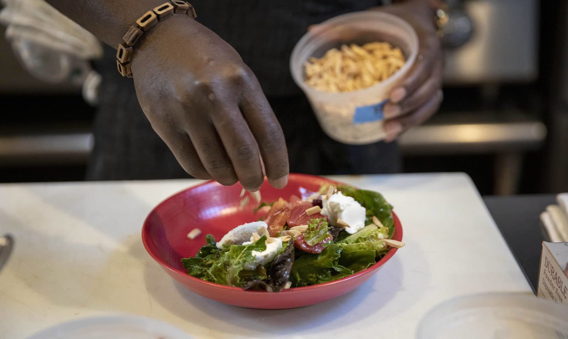 Chef Kwasi Kwaa makes a salad at Comfort Kitchen. (Robin Lubbock/WBUR)